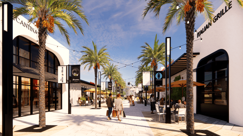A store-lined sidewalk through an outdoor mall.
