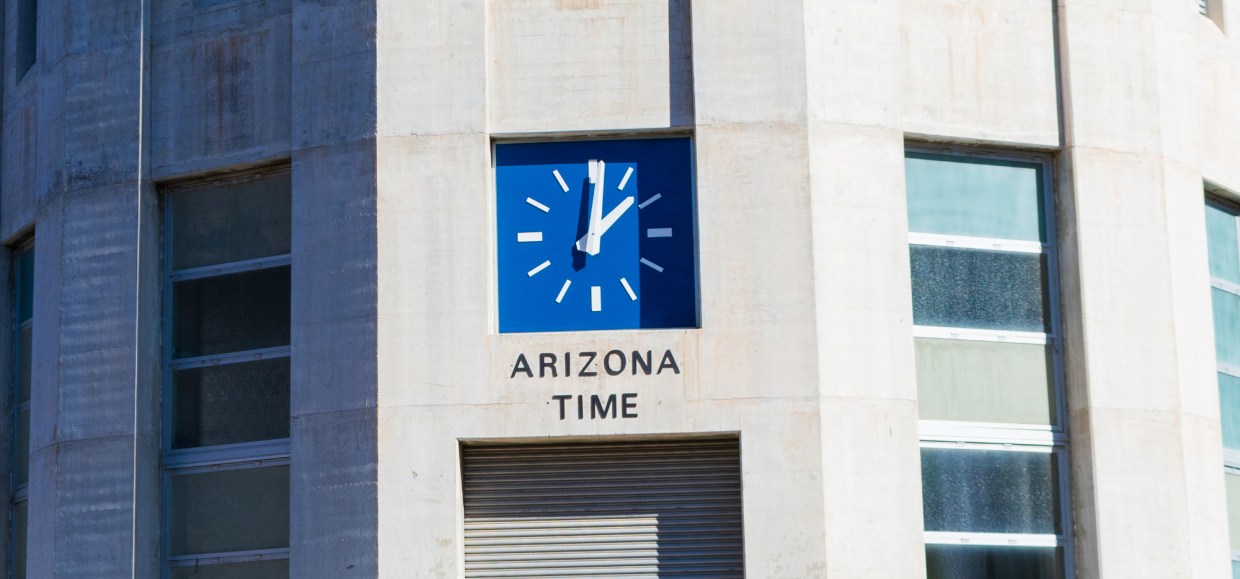 a blue clock on the arizona side of the hoover dam showing 'arizona time'