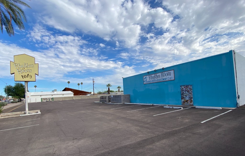 The parking lot and exterior of a squat blues club.