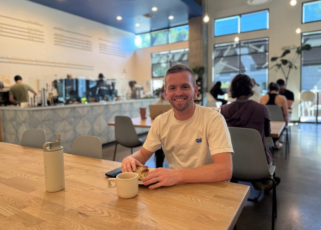 Man sitting at a table in a coffee shop.