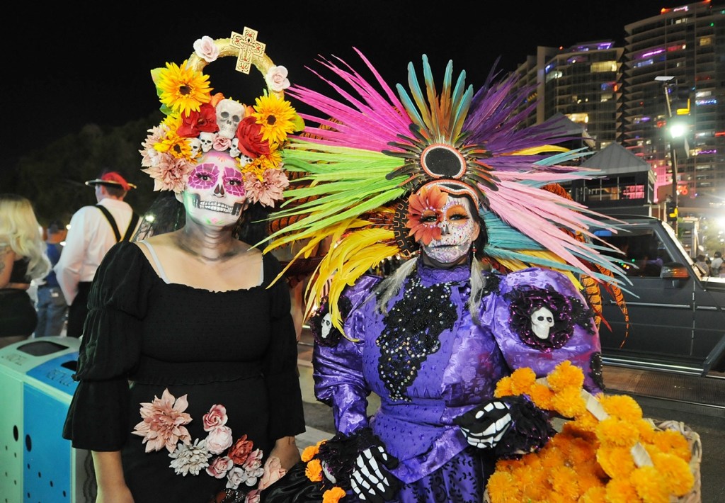 Two women dressed in Day of the Dead costumes in a downtown area.