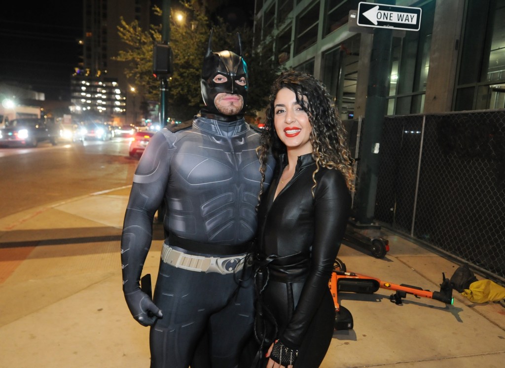 A man dressed as Batman stands next to a woman dressed as Catwoman.