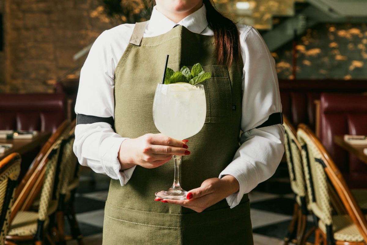 A waitress holding a spritz.