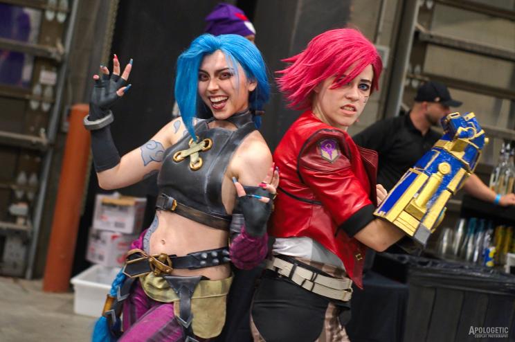 Two female cosplayers standing back to back.