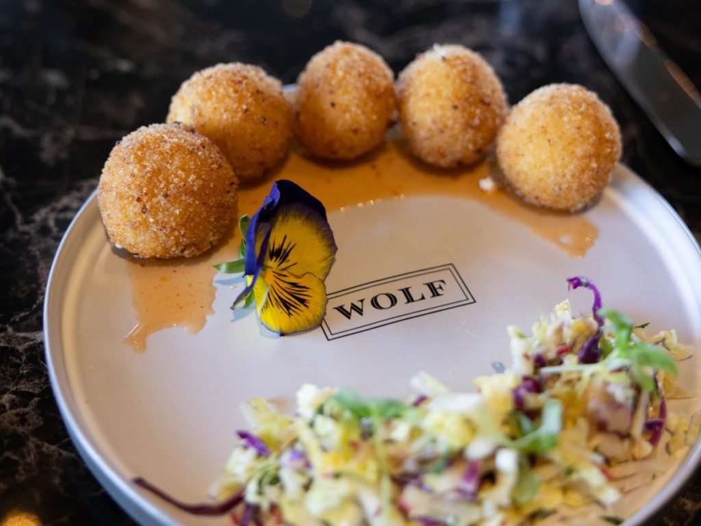 A plate of fried goat cheese balls with a slaw.
