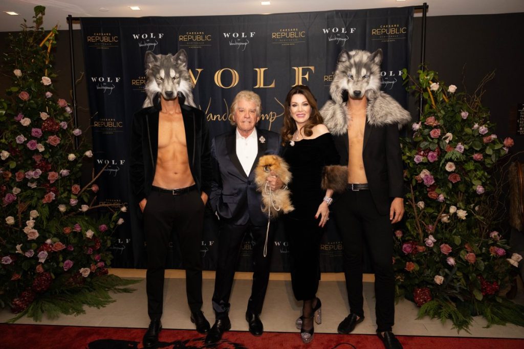 Lisa Vanderpump and Ken Todd pose with two models wearing wolf heads.
