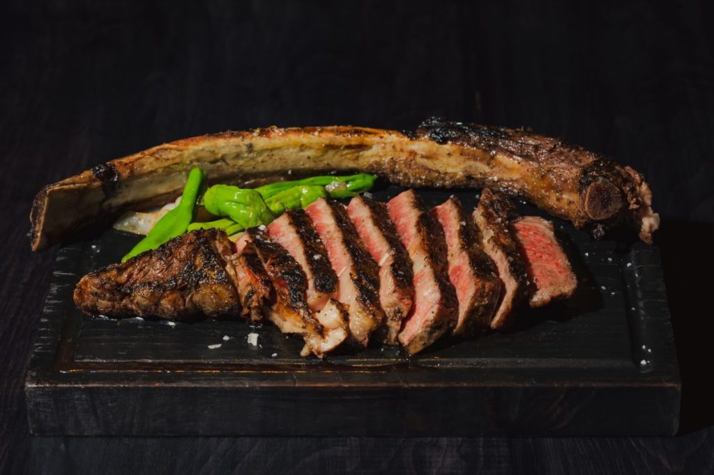 A tomahawk steak on a wood platter.