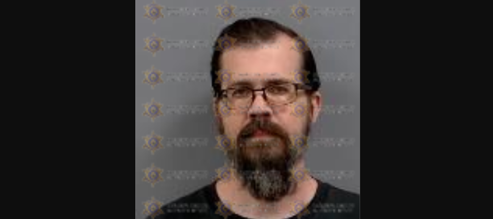 a mugshot of a bearded man