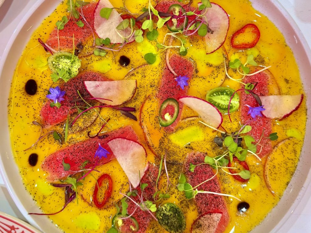 A plate of raw fish in a sauce.