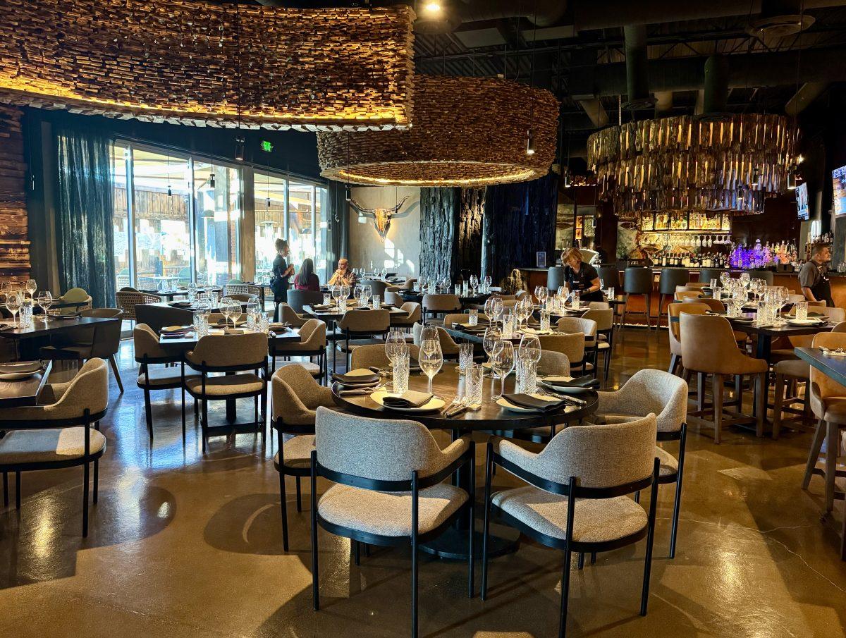 An elegant dining room with rustic wood chandeliers.