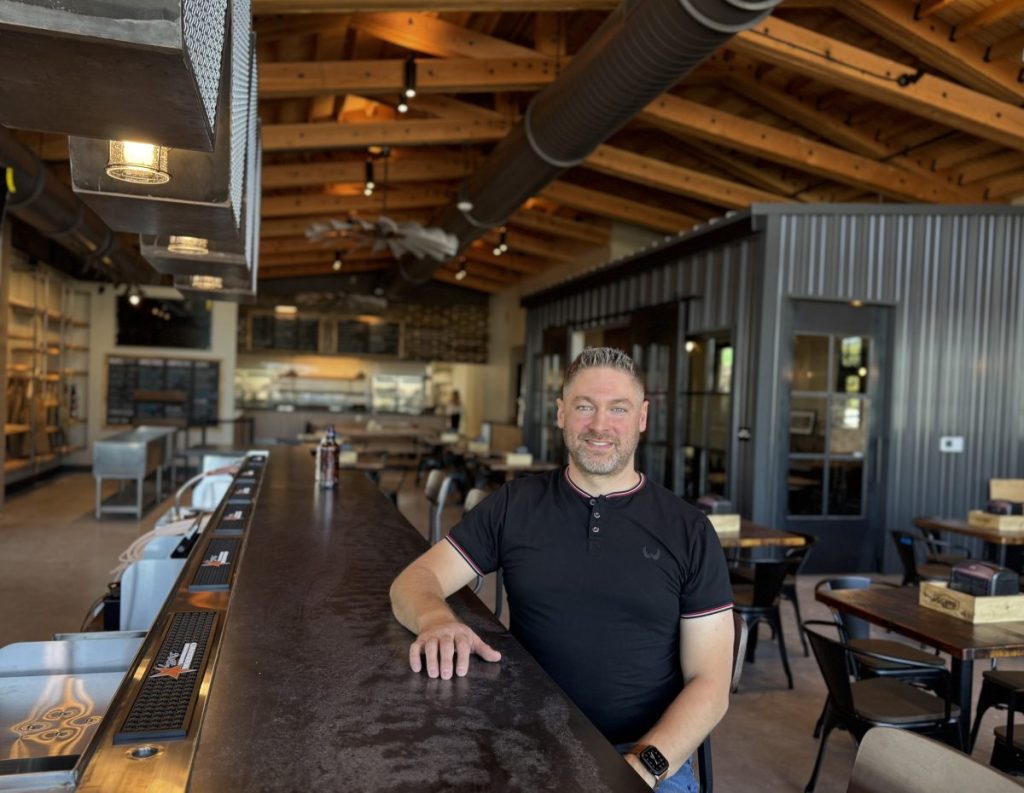 A man at a bar in a smokehouse.