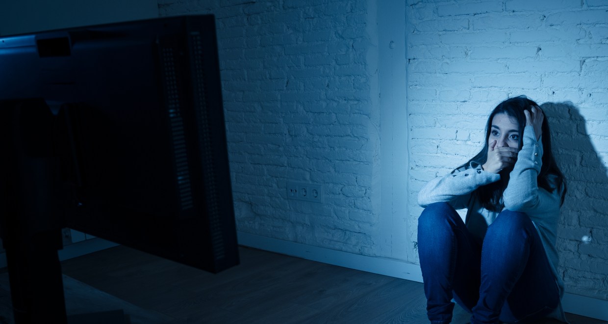 a woman covers her face in front of a screen