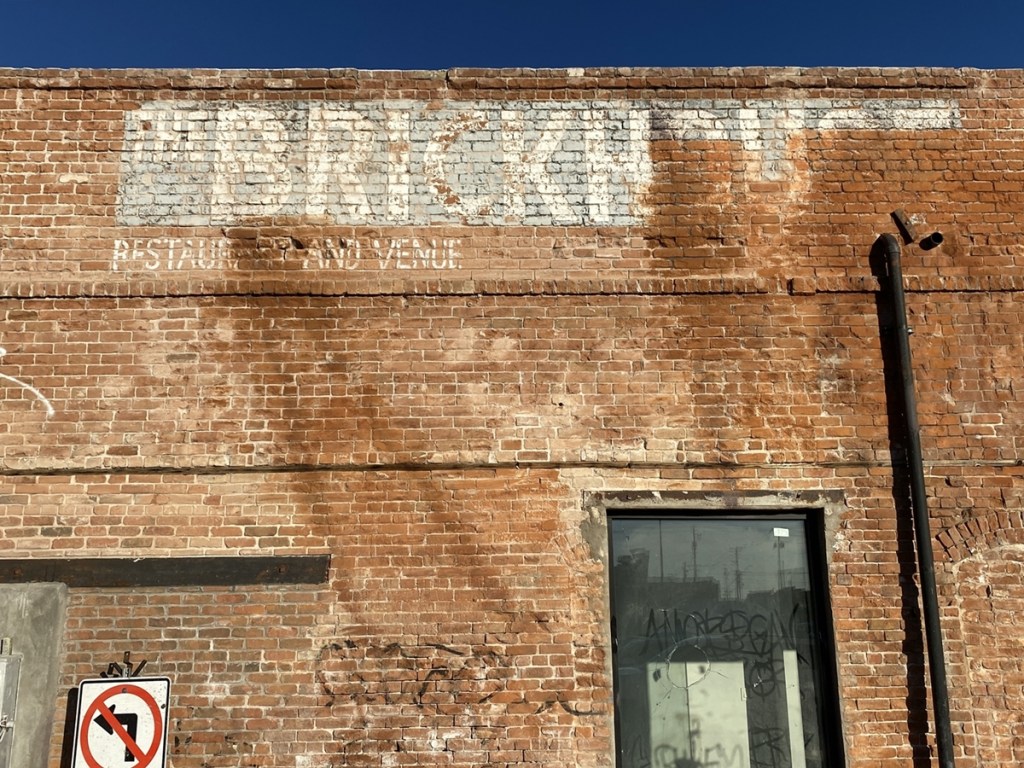 A historic red brick building with the words "Brickhouse venue and restaurant" along the top in faded white paint.