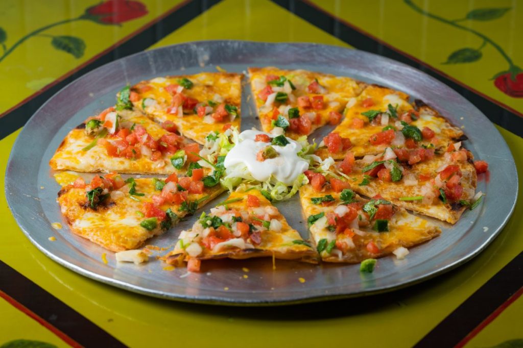 A cheese crisp on a platter.