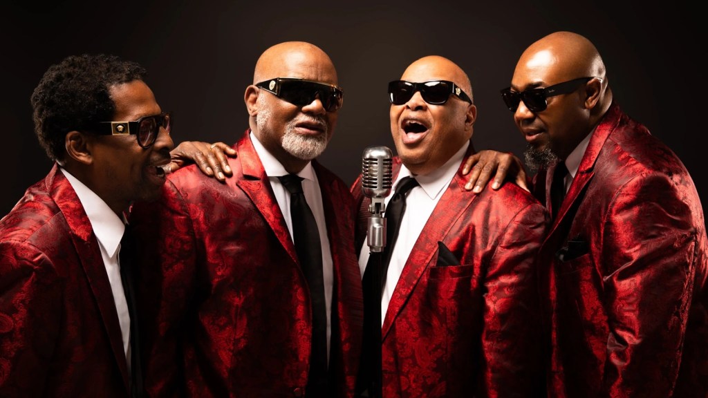 The Blind Boys of Alabama’s current lineup poses together in matching red jackets.