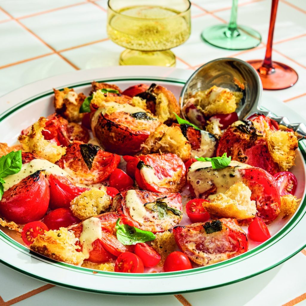 A broiled tomato Caesar salad on a large platter.