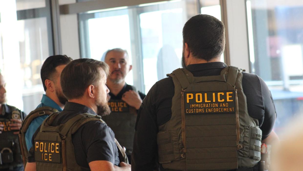three ice agents stand at sky harbor airport