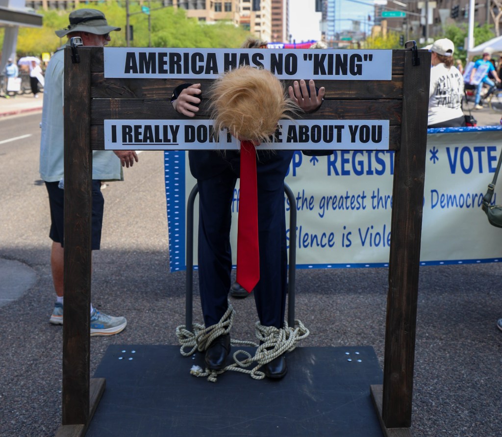 a protester dresses as trump locked in a stockade