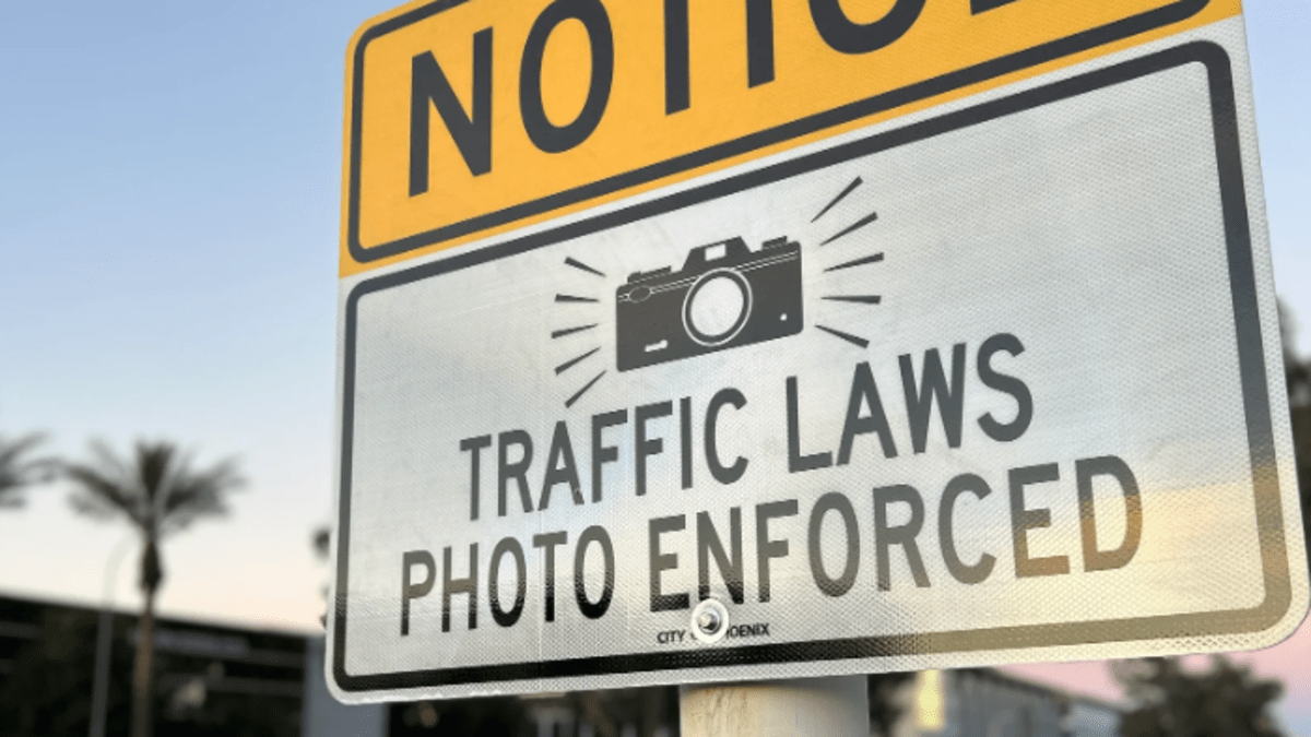 a sign with a camera logo that says "traffic laws photo enforced"
