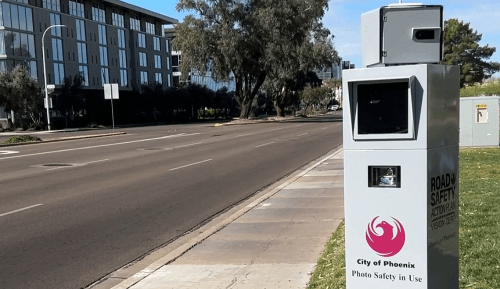 a speed camera in a gray casing with the city of phoenix logo on it