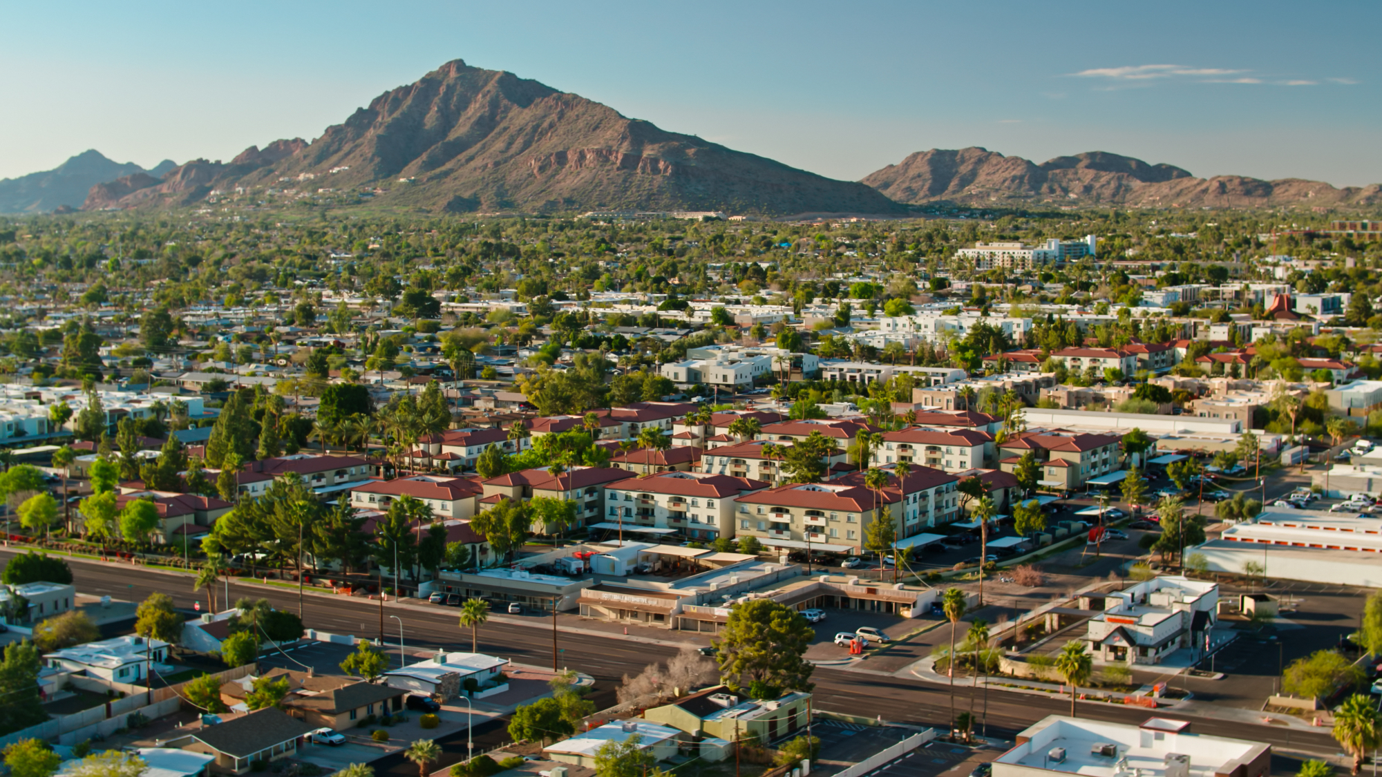 an aerial view of houses in scottsdale, with camelback mountain in the background