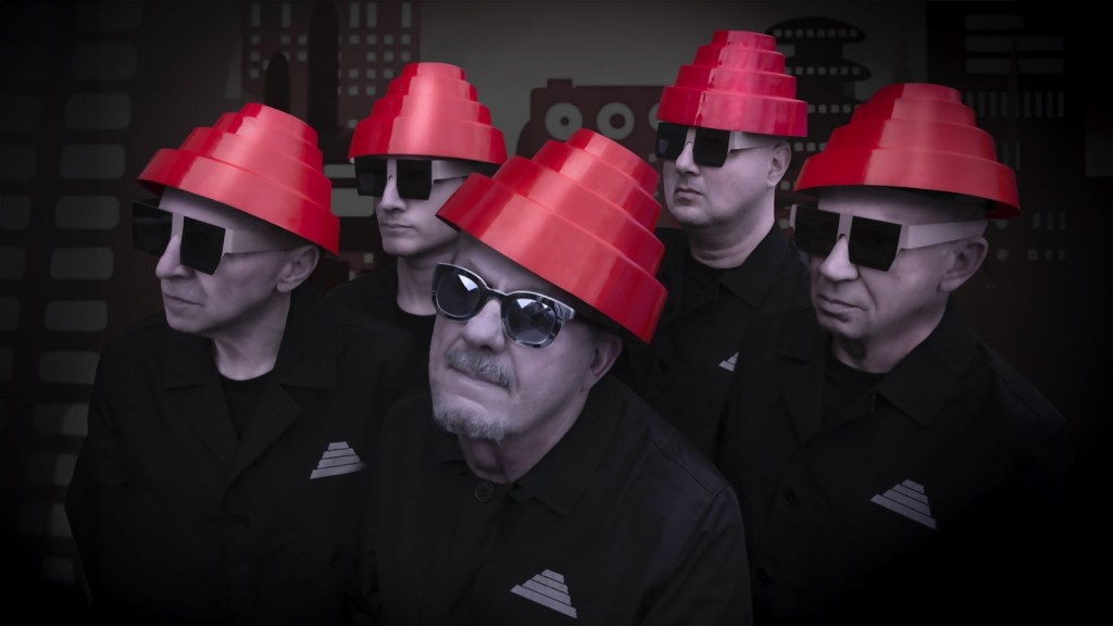 Devo band members wearing red energy dome hats in a promotional photo for their 2026 tour.