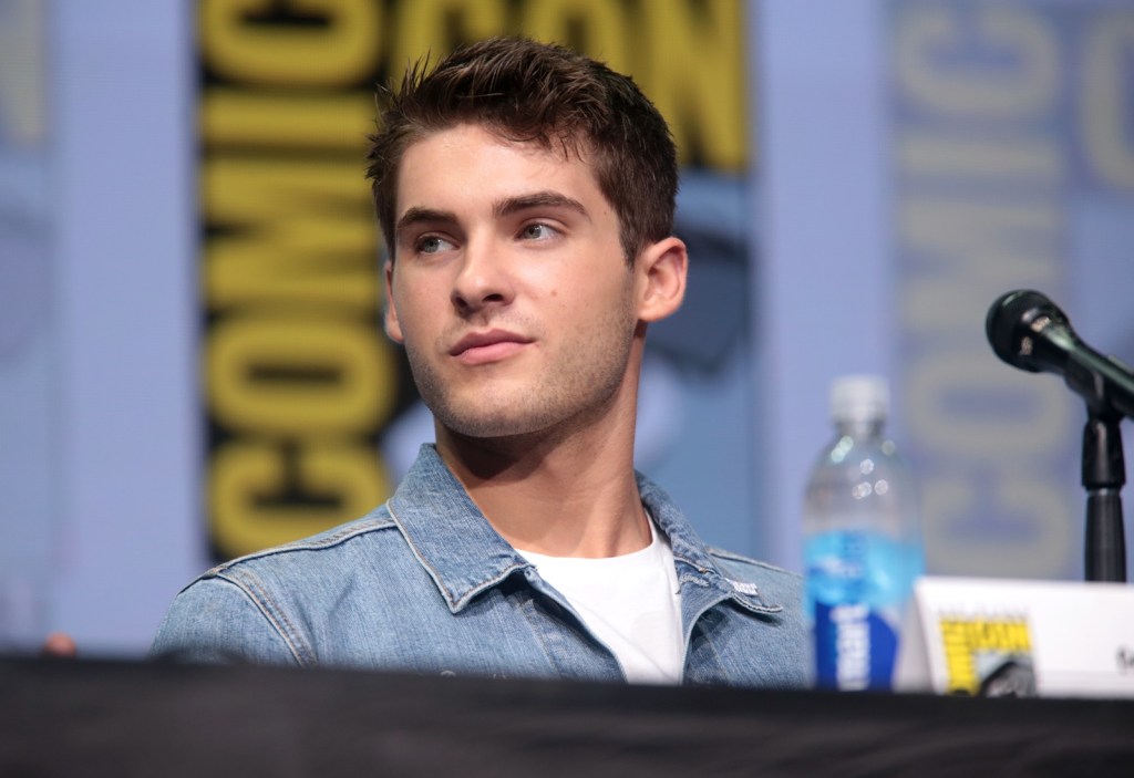 Actor Cody Christian sitting behind a microphone at San Diego Comic-Con in 2017.