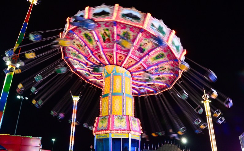 A brightly lit swing ride spins at night at the Maricopa County Fair in Phoenix.