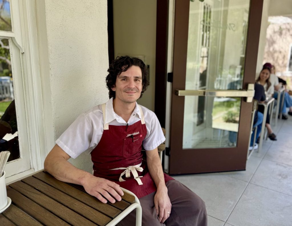 Chef Matt Celaya sits on a patio table in front of the all-day cafe Matilda's.