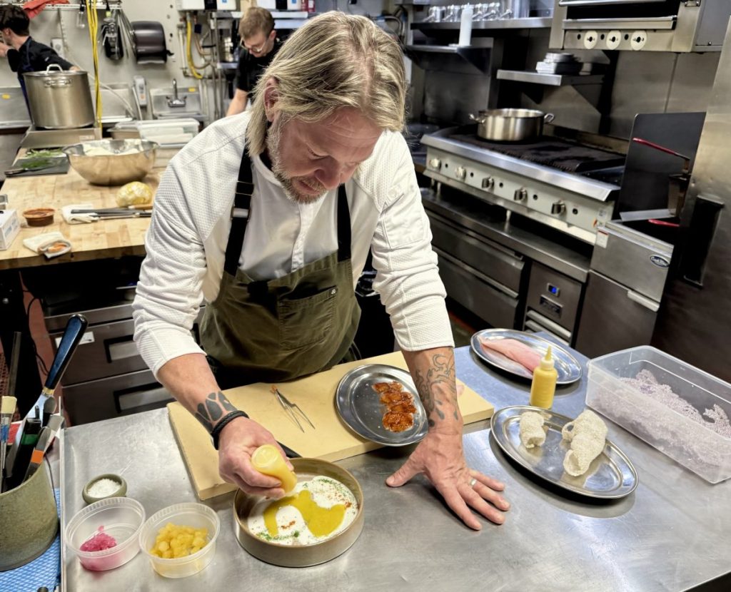 Chef Steven "Chops" Smith adds a pineapple and passion fruit aguachile to a plate.