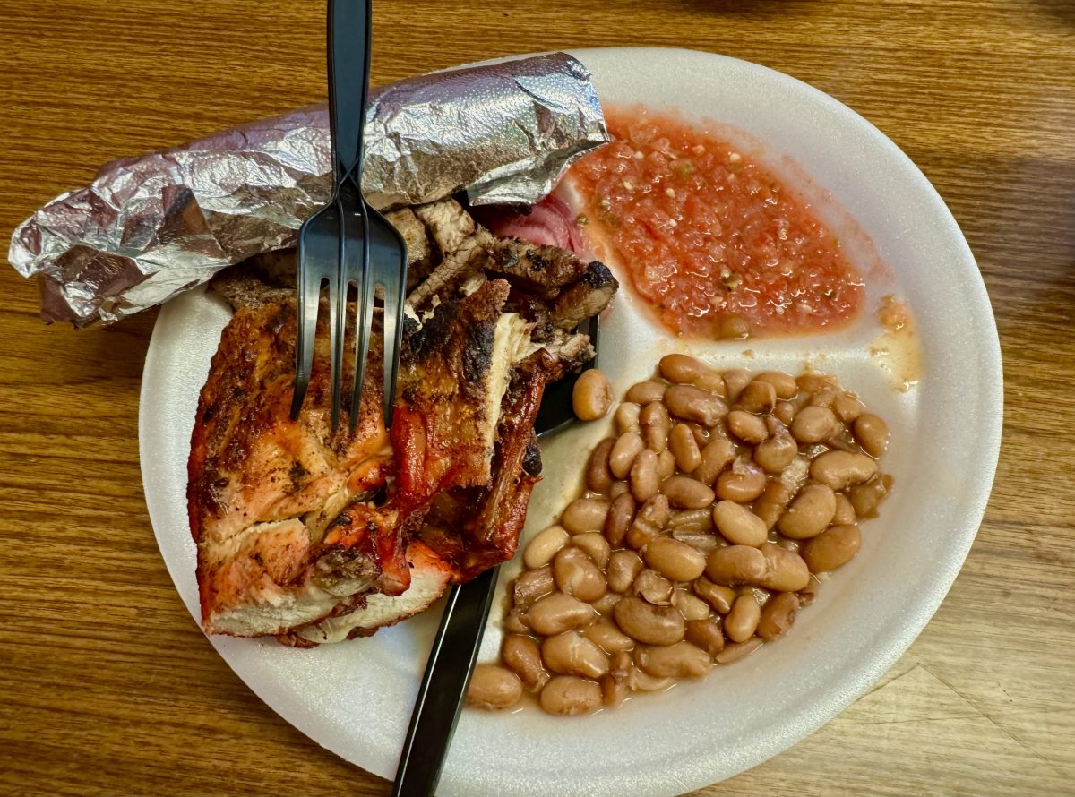 A styrofoam plate filled with grilled chicken, beef, pinto beans, salsa and a bundle of tortillas wrapped in foil from El Pollo Supremo.