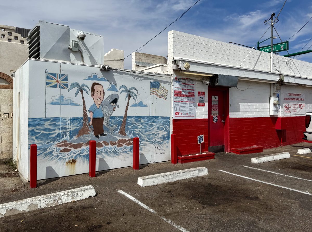 A mural on the side of a Phoenix location of Pete's Fish & Chips shows a man holding a fish on an island.