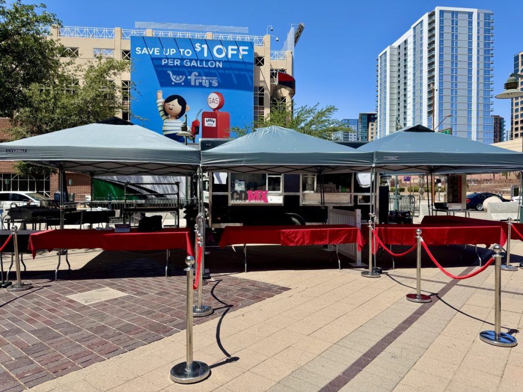 Three pop-up tents and a food trailer outside of Chase Field.