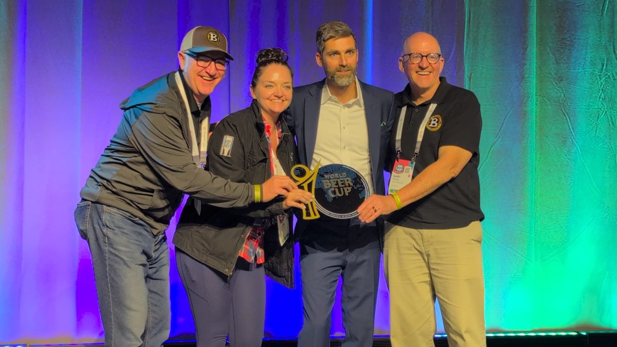 Barrio Brewing Co. team poses with Brewers Association representatives with World Beer Cup placard.