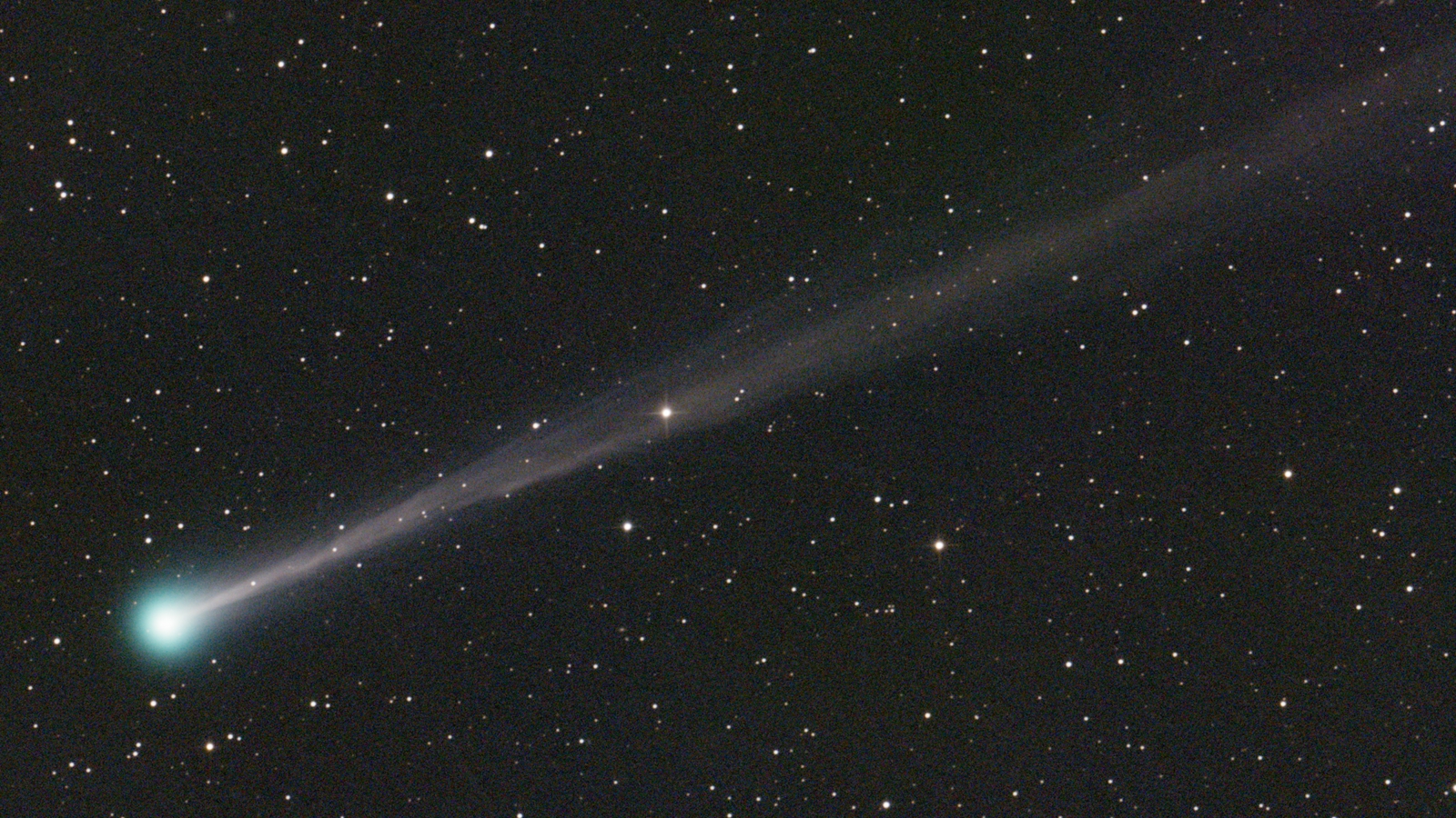 Comet C/2025 R3 (PanSTARRS) with a long glowing tail against a star-filled night sky