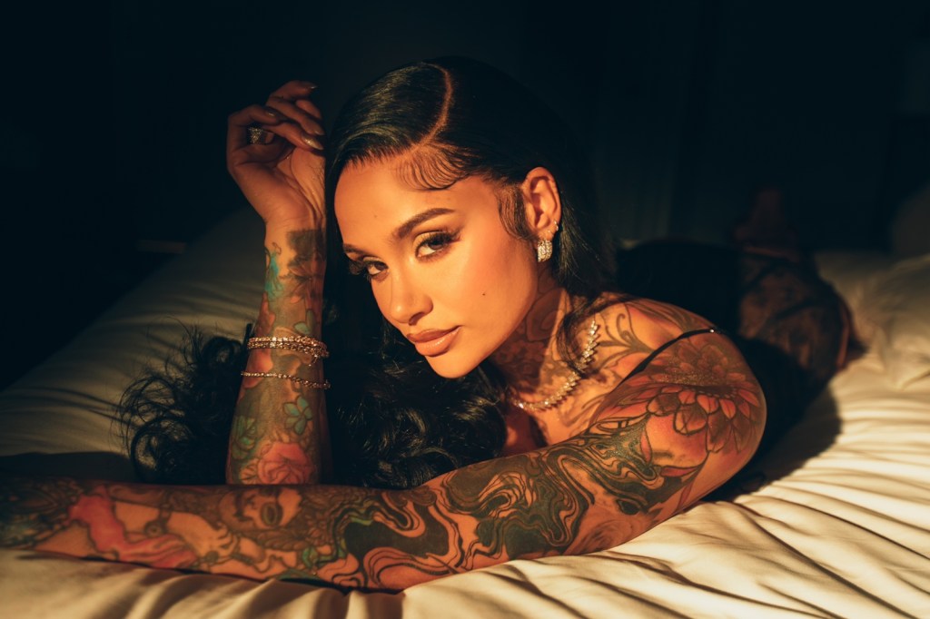 Kehlani poses on a bed in a promotional photo.
