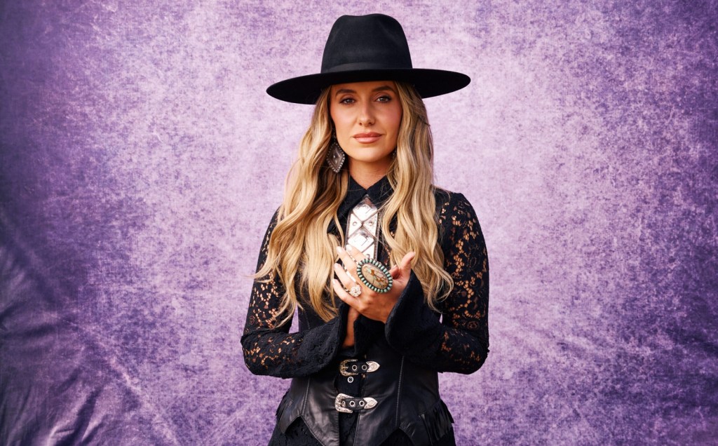 Lainey Wilson poses in a black hat and western outfit for a press photo ahead of her Country Thunder Arizona 2026 performance