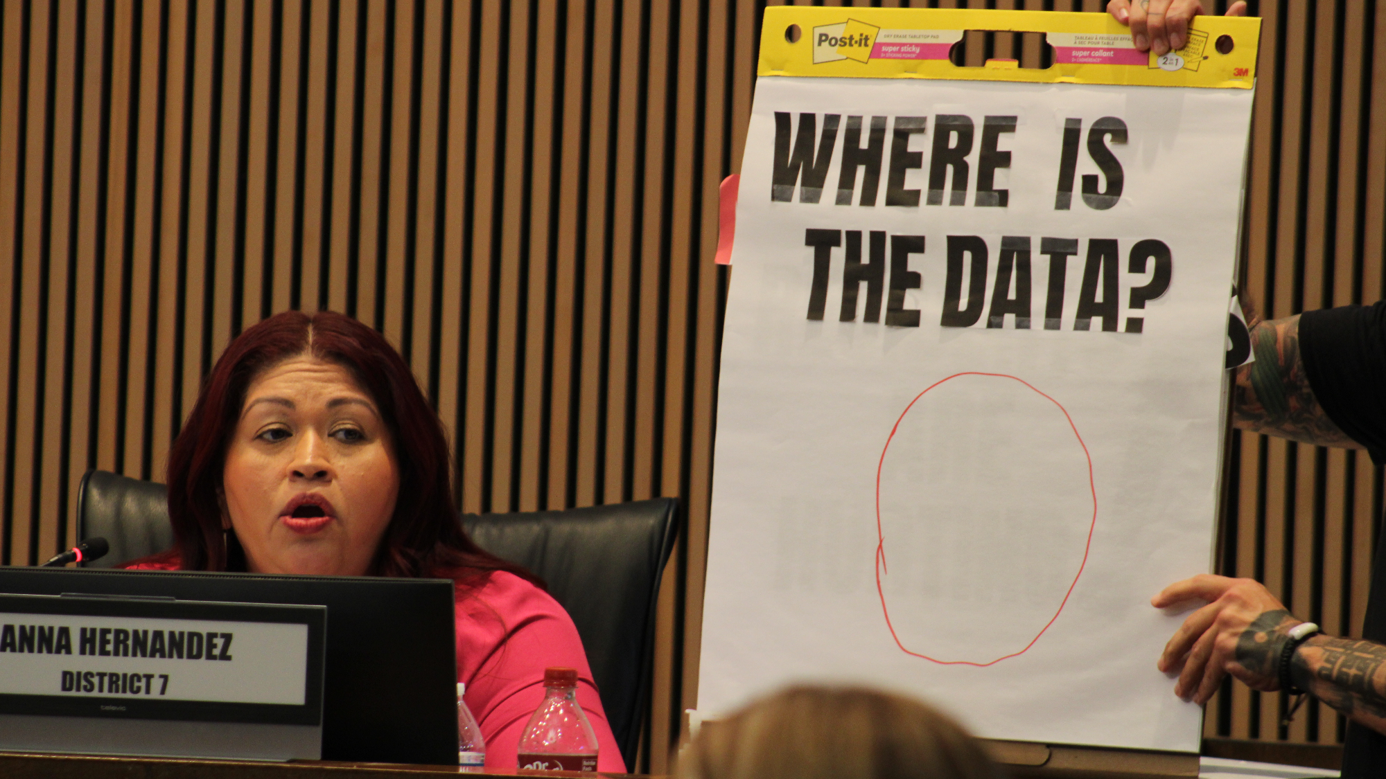 anna hernandez speaks as someone holds up a huge notepad that says "where is the data?" with a big zero drawn on it
