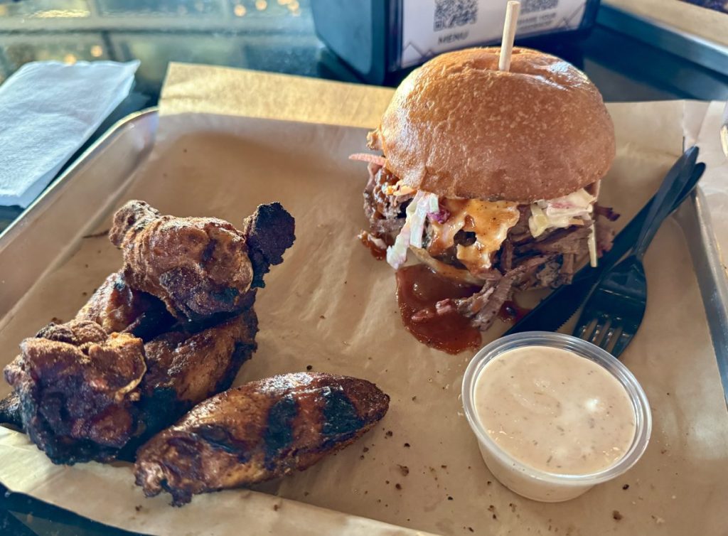A platter with wings and a brisket sandwich.