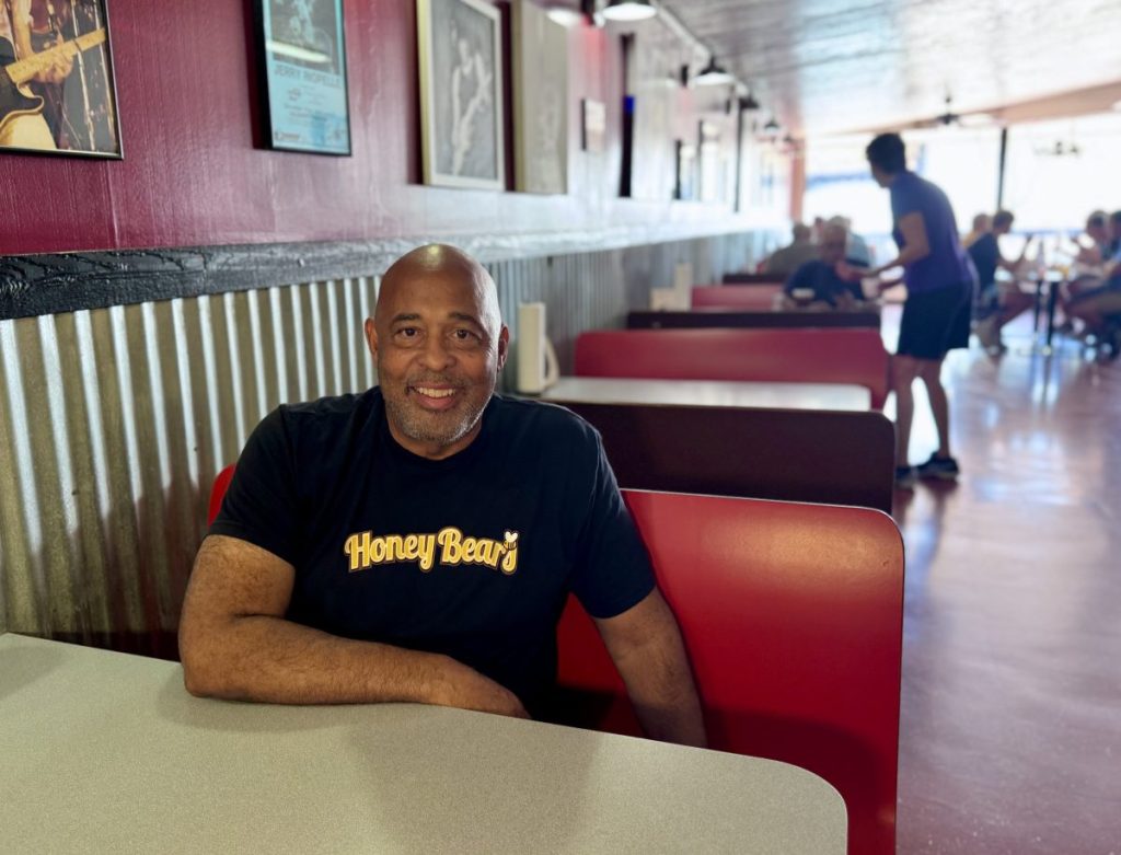 Honey Bear's BBQ owner Mark Smith poses in a booth at his restaurant.
