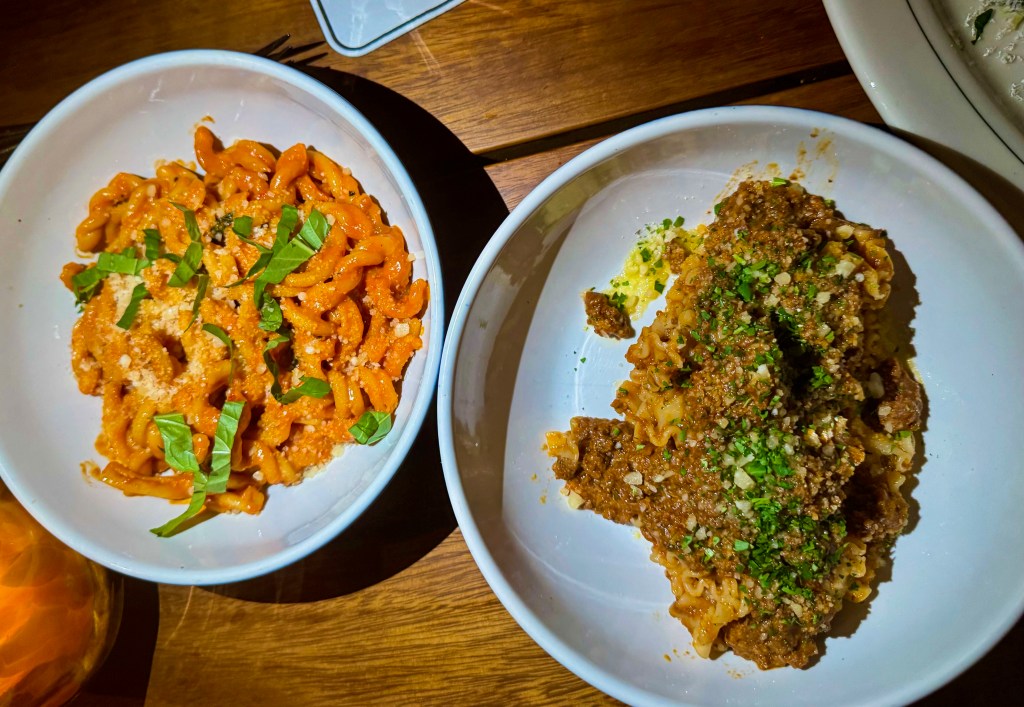 Two bowls of pasta on a table.