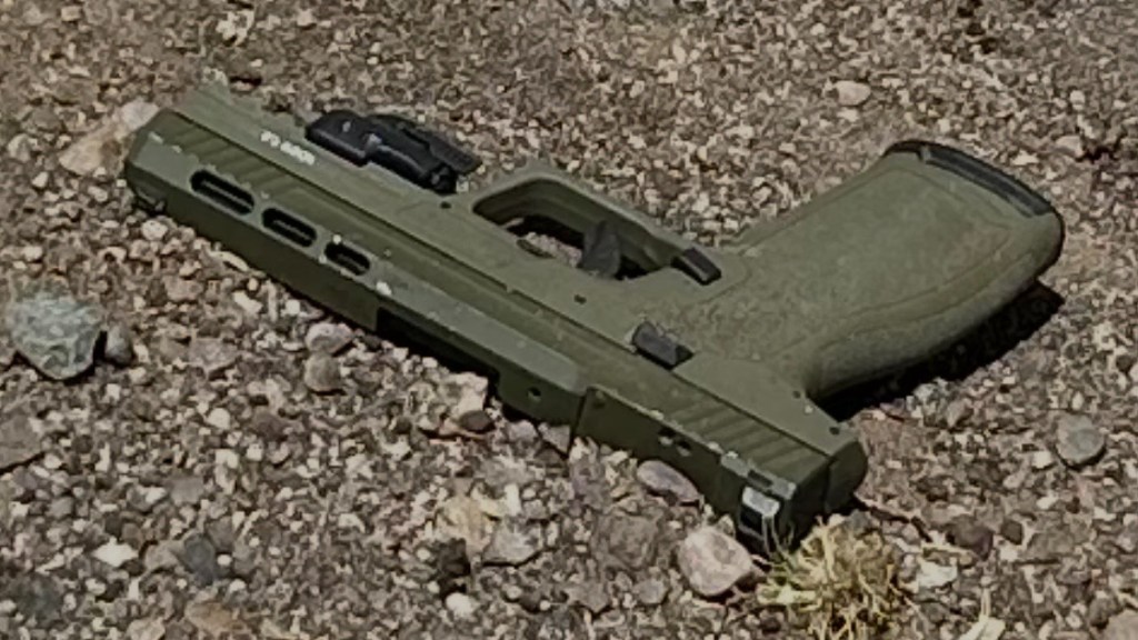 a forest green handgun on the ground