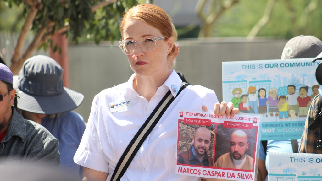 Elizabeth Lee holds a photo of Marcos Gaspar Da Silva at a protest