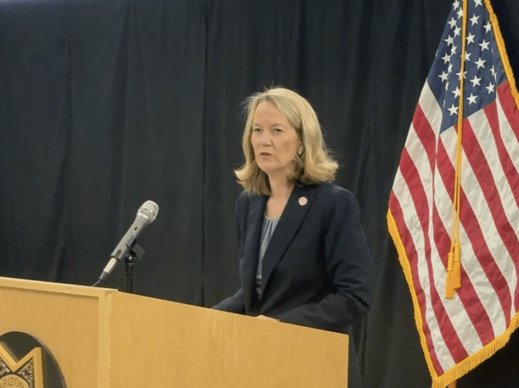 Kris Mayes, Arizona's attorney general, stands at a lectern