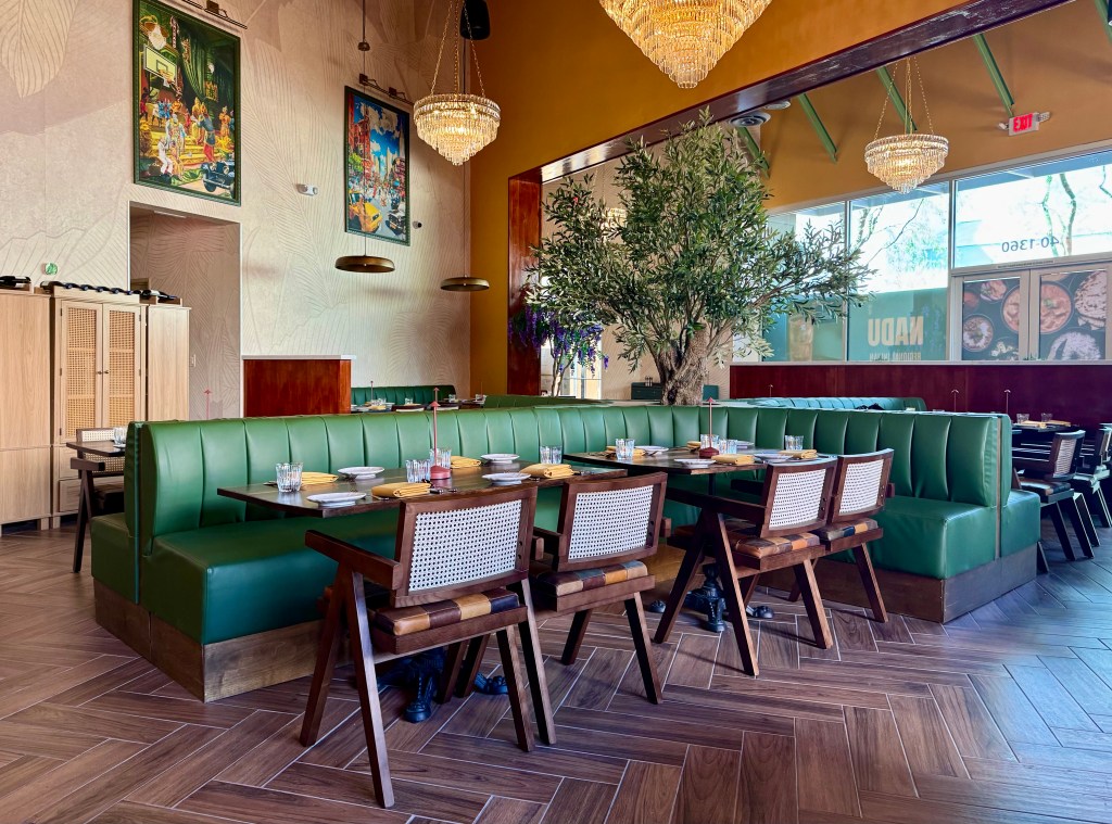A long green booth and tables in Nadu's dining room.