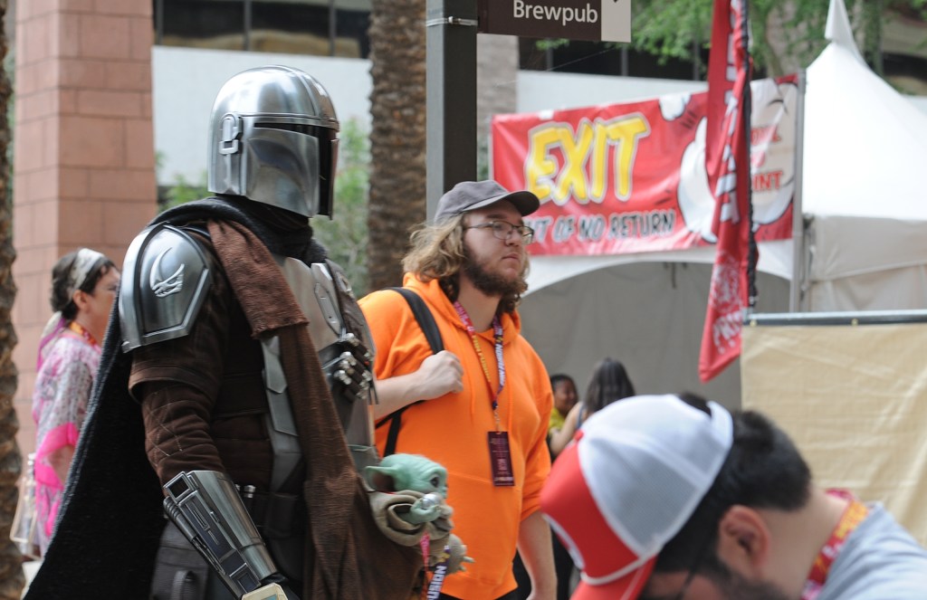 A cosplayer dressed as Din Djarin from "The Mandalorian" walks into the Phoenix Convention Center during Phoenix Fan Fusion 2026.