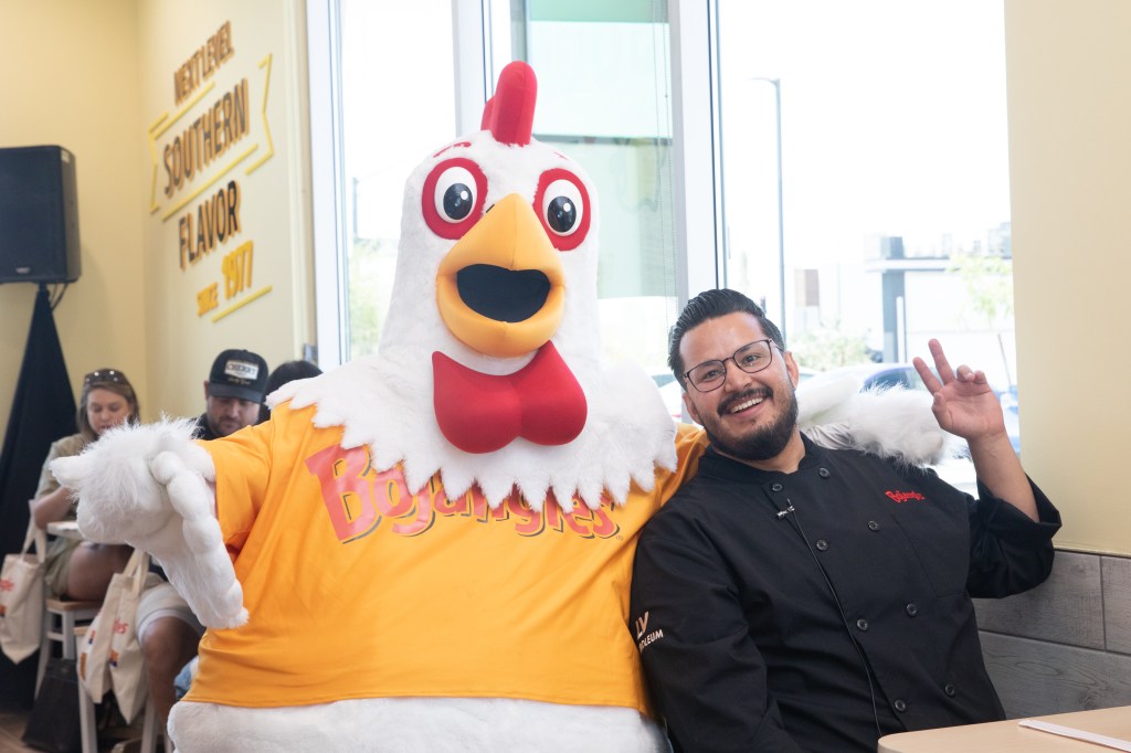 A Bojangles mascot and chef sit at a table in the Gilbert restaurant.
