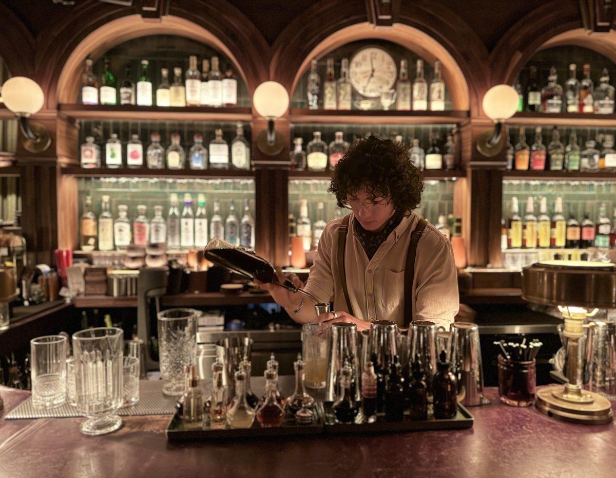 Trophy Room's lead bartender Damion Mendoza measures out a drink.