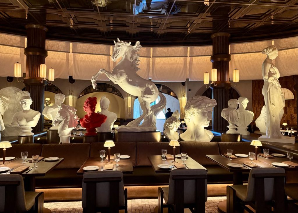 A gallery of sculptures and busts cuts through the middle of the dining room at Roman God of Fire.