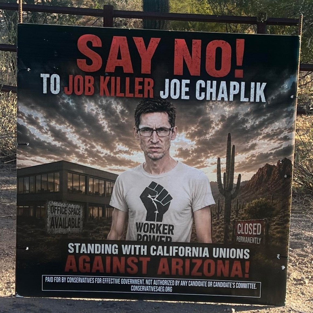 an anti-joseph chaplik attack ad featuring an AI image of him in a worker power shirt with a black fist. he stands in front of en empty office building. it says "say no to job killer joe chaplik"